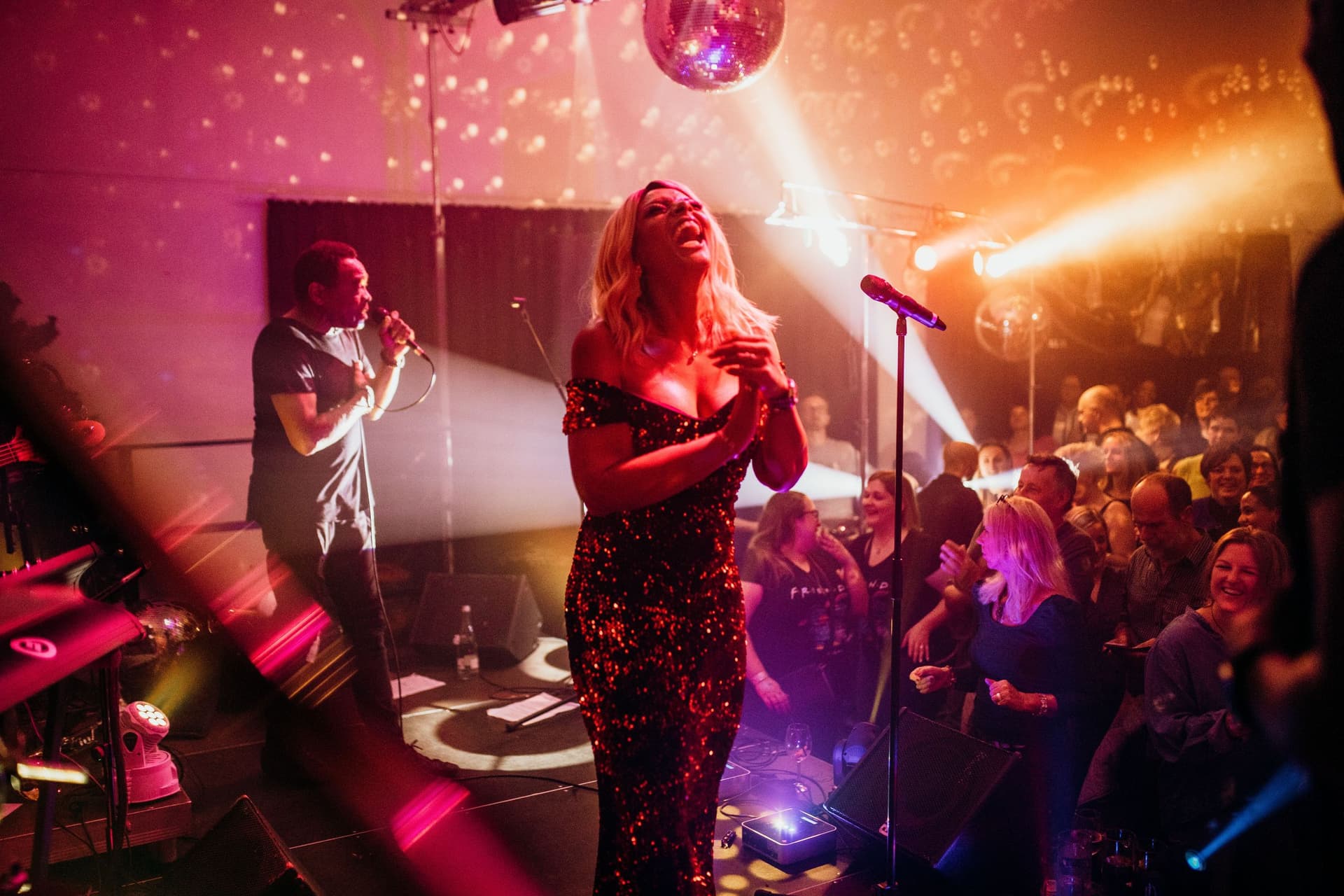 Amy Sue auf der Bühne mit Discokugel und begeistertem Publikum