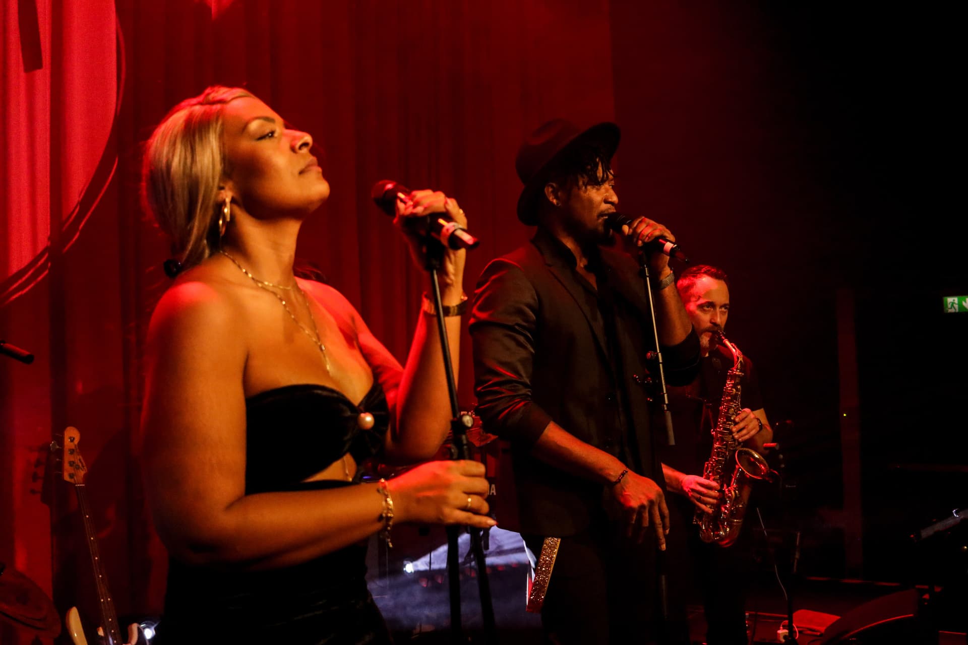 Amy Sue und Klyive in emotionalem Moment bei rotem Bühnenlicht