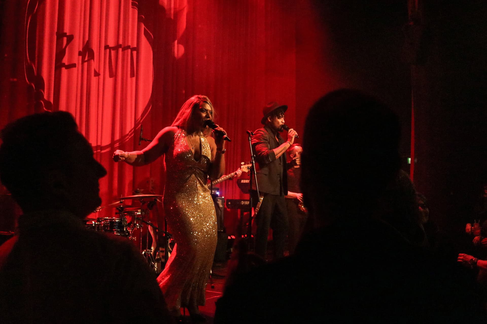 Amy Sue und Klyive performen, Publikum als Silhouette im Vordergrund