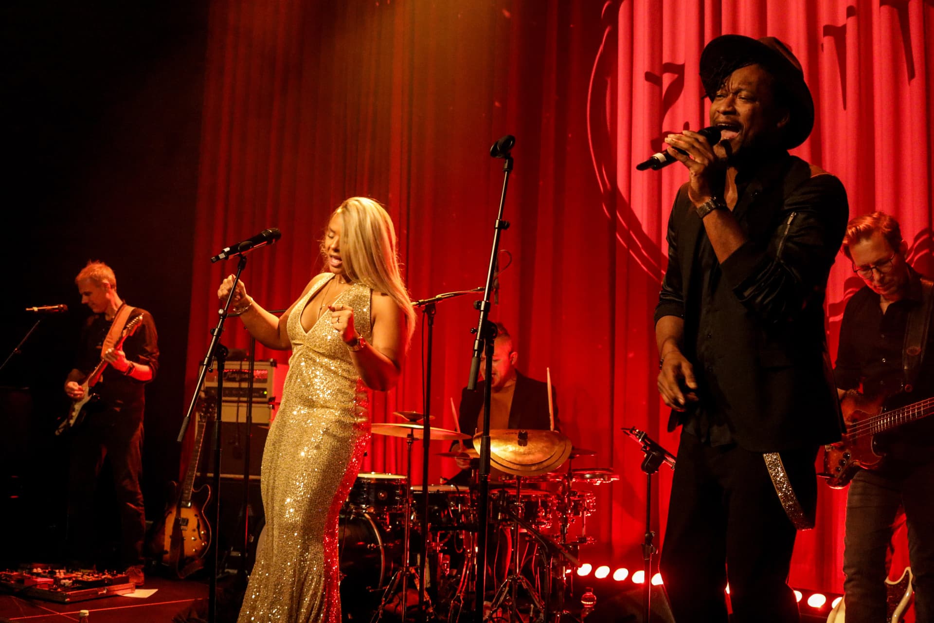 Amy Sue und Klyive gemeinsam performend auf der Bühne mit rotem Vorhang