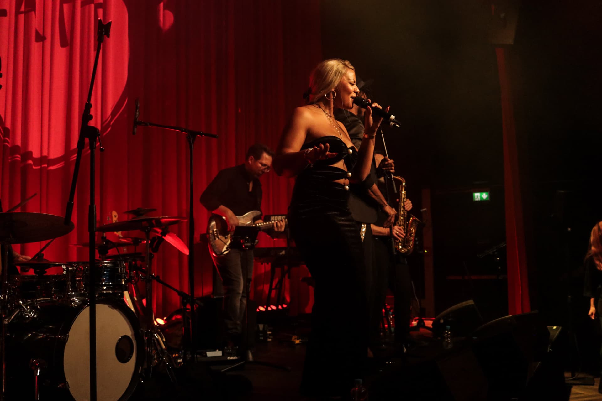 Amy Sue im eleganten schwarzen Kleid performt mit Saxophon