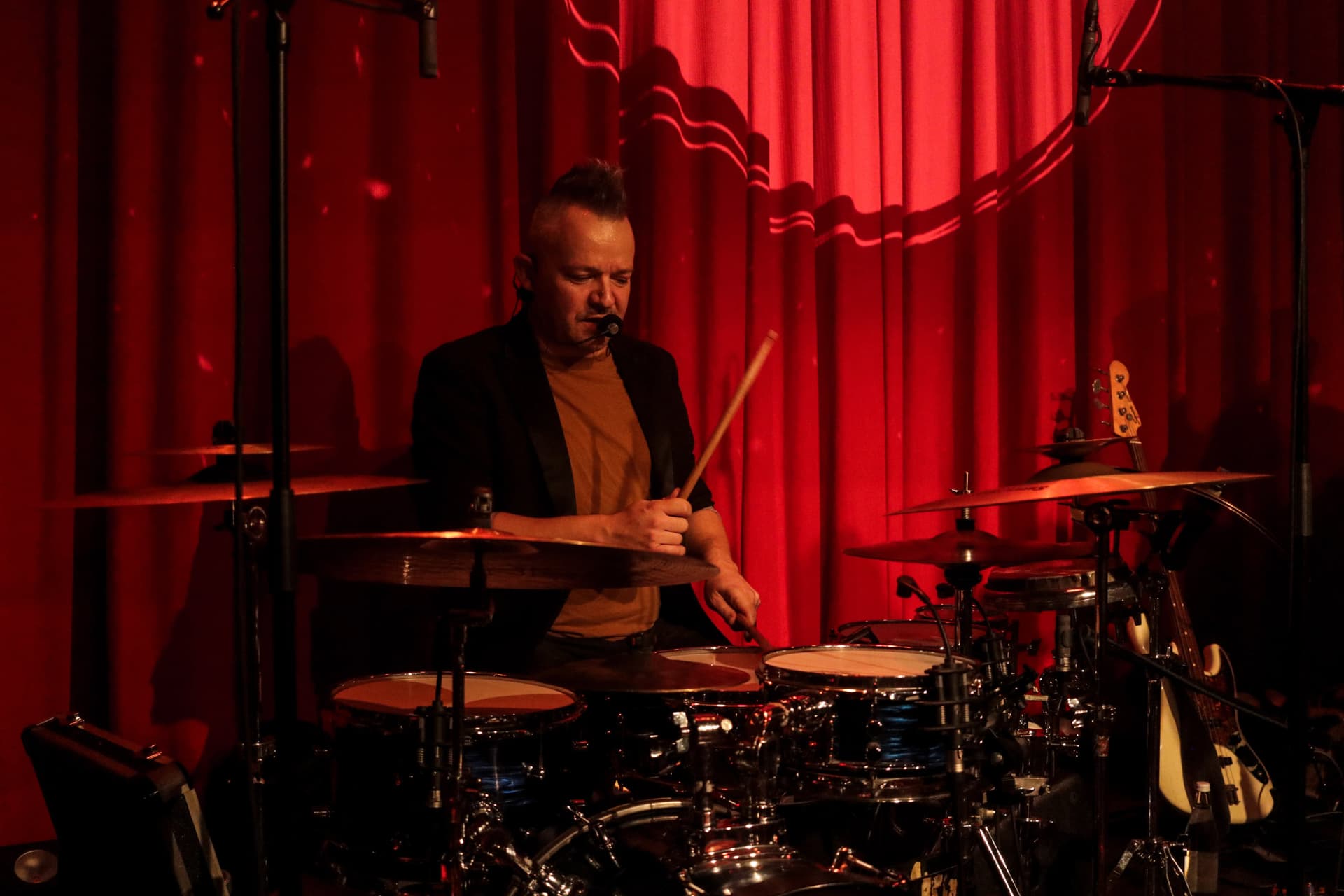 Drummer Steffen Liede spielt konzentriert vor rotem Bühnenvorhang