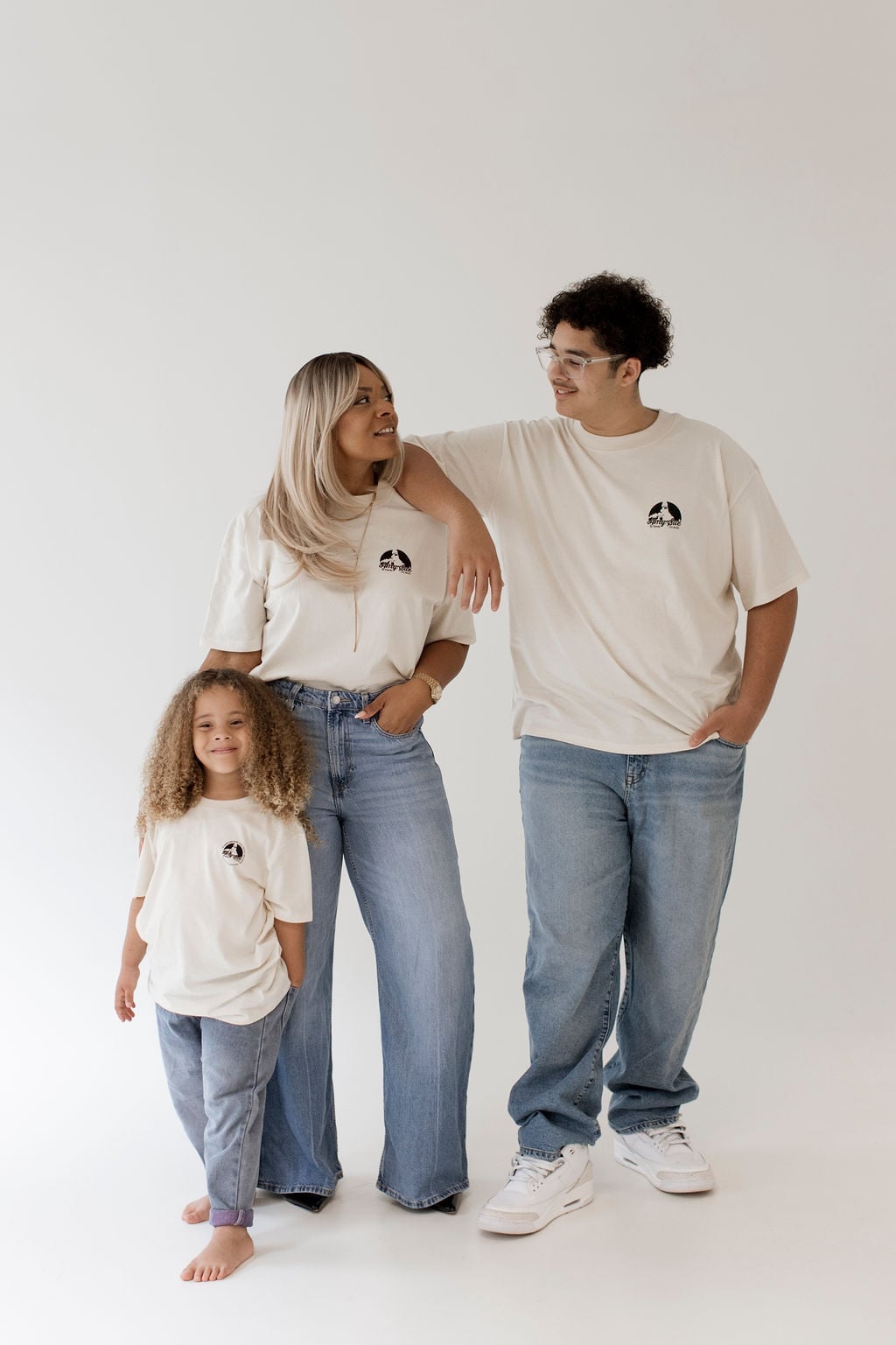 Amy Sue mit Kind und Jugendlichem, alle drei stehend im Cream-Shirt — Kindershirt vorne im Fokus