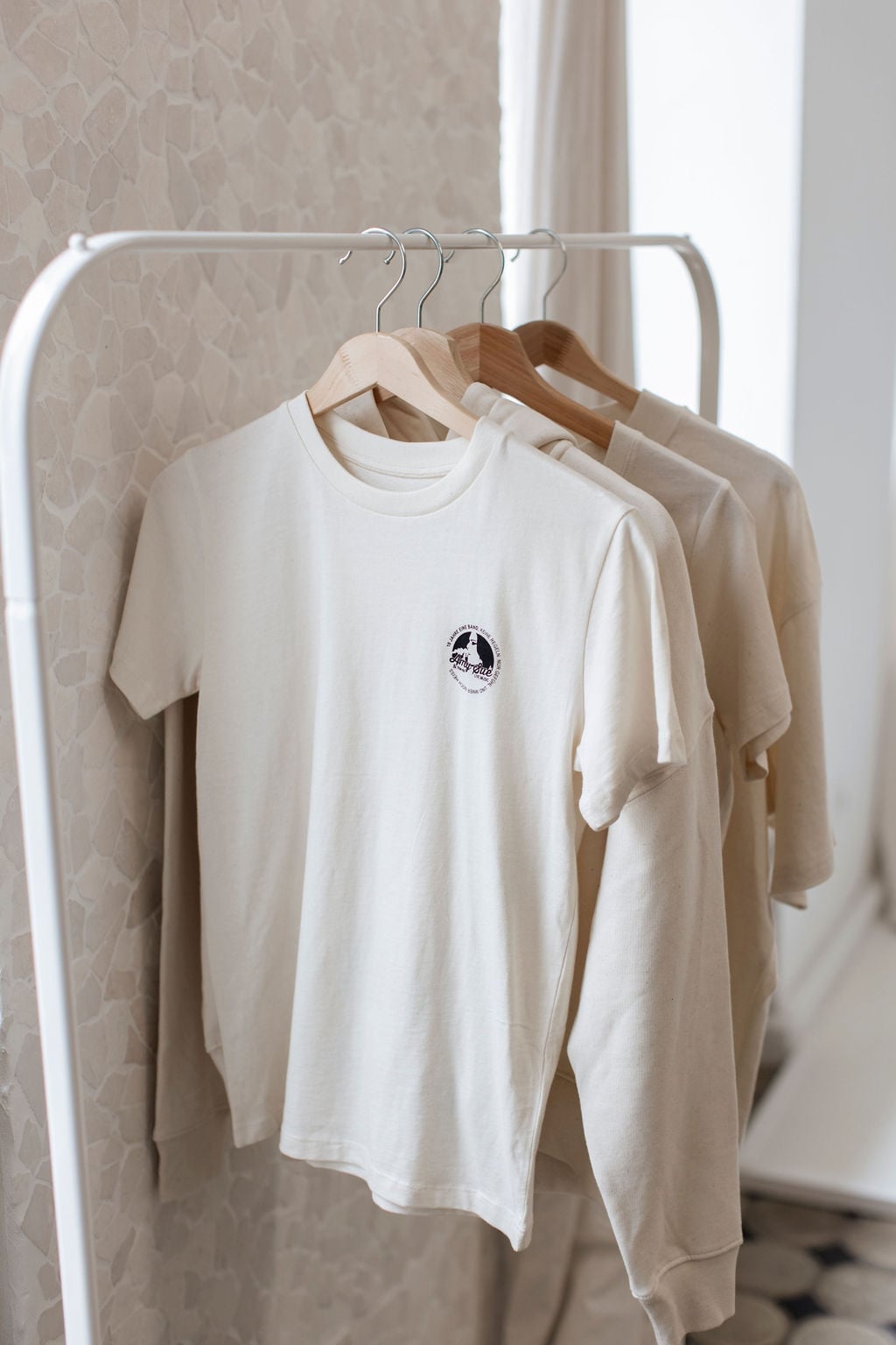 Drei T-Shirts der Jubiläums-Kollektion auf der Kleiderstange, Chest-Logo prominent